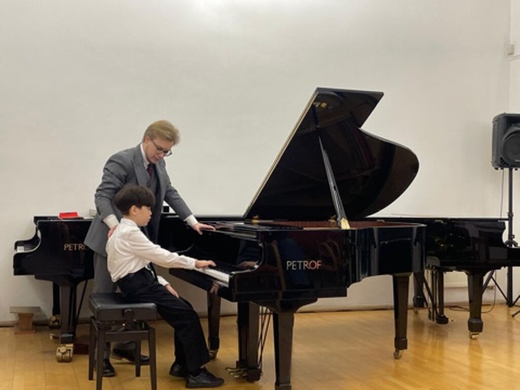 Преподаватель и ученик за роялем 