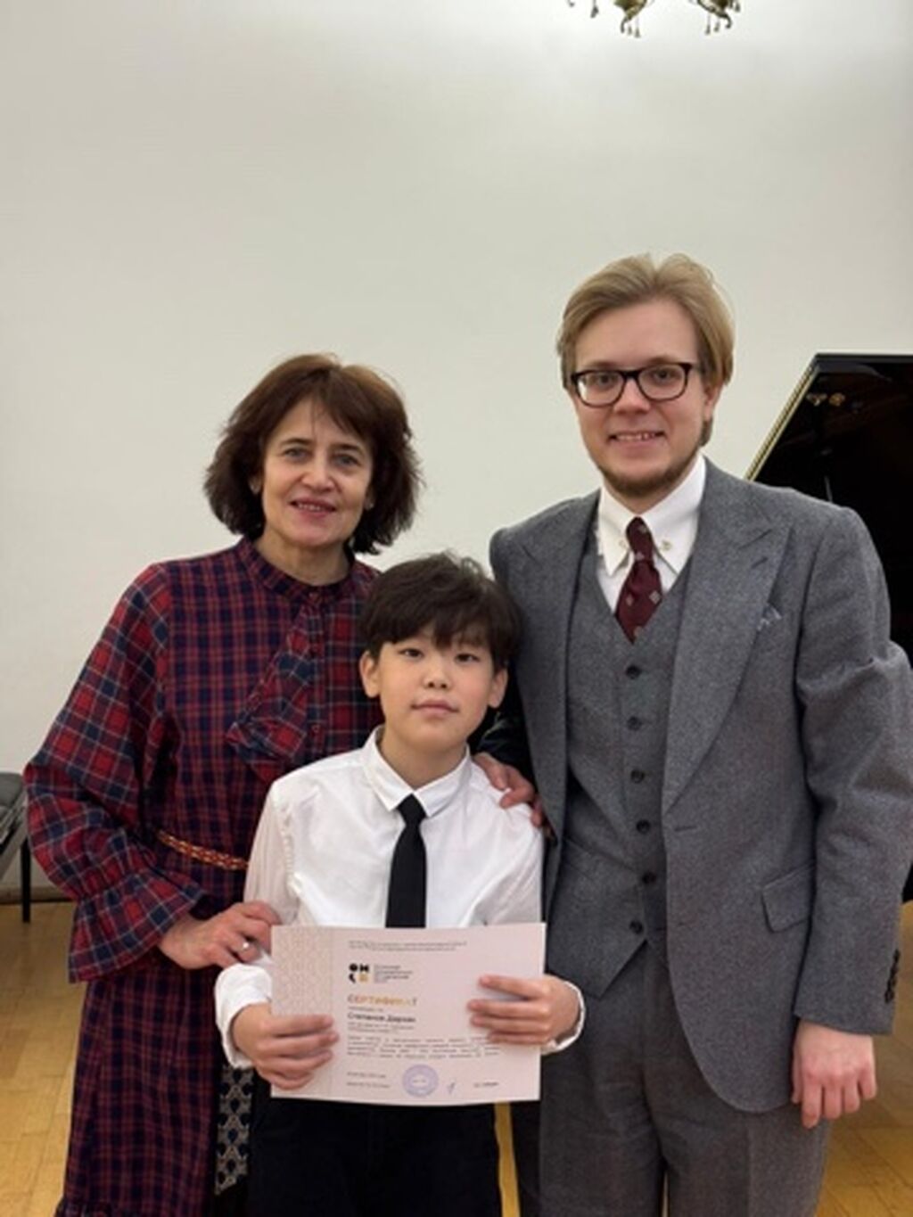 Два преподавателя и ученик с сертификатом