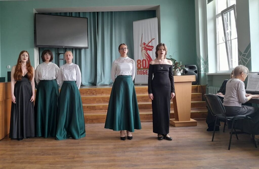 Девочки поют, впереди солистка поёт, за роялем - концертмейстер